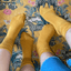 Bamboo socks in a vibrant yellow colour worn by two people on a bright patterned background.