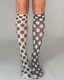 A pair of odd dot knee high socks in sheer white material with bold black polka dot pattern